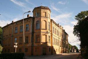 an old building with a clock tower on a street at Vintage Rooms in Kuldīga