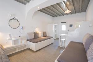 a room with a bed and a sink and a mirror at Zisis Pension in Agios Stefanos