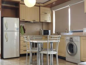 a kitchen with a table and chairs and a refrigerator at Lavrio port-centre 1bdr Apt with balcony wash machine in Lavrio