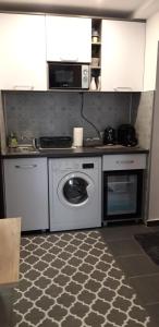 a kitchen with a washing machine and a microwave at Studio Callatis Central - adults only in Mangalia