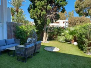 a garden with a blue couch and chairs on the grass at Urbanizacion Puerto Rey in Vera