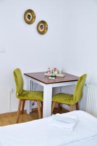 stół jadalny z 2 zielonymi krzesłami w obiekcie Guesthouse Marivo w mieście Jajce