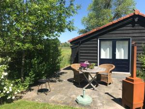 un patio con mesa y sillas frente a una cabaña en ''Op Stok", en Bergen