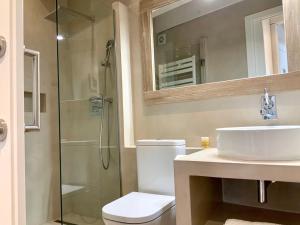a bathroom with a toilet and a sink and a shower at Dúplex Can Quim, Terrace Boutique Apartment in L'Escala +36 photos