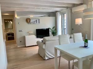 a living room with a white couch and a table at Dúplex Can Quim, Terrace Boutique Apartment in L'Escala