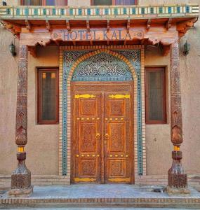 een toegang tot een gebouw met een houten deur bij HOTEL KALA KHIVA in Khiva