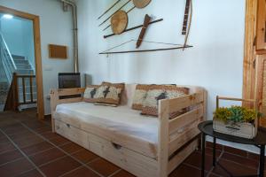 a bed in a room with a cross on the wall at La casa de la abuela Regina in Grazalema
