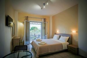 a bedroom with a bed and a table and a window at Yria ntn Studios in Vanáton