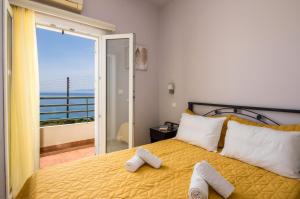 a bedroom with a yellow bed with towels on it at Asta La Vista Maisonettes in Pesádha