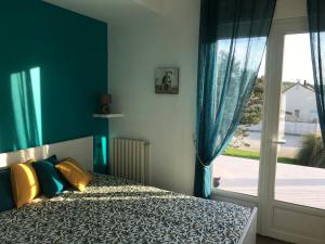 a bedroom with a bed and a large window at La Villa Port Winston - Face Mer B&B in Saint-Côme-de-Fresné