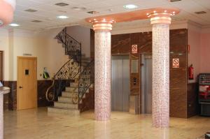 un vestíbulo con 2 columnas y una escalera de caracol en Hotel Vent de Mar, en Puerto Sagunto