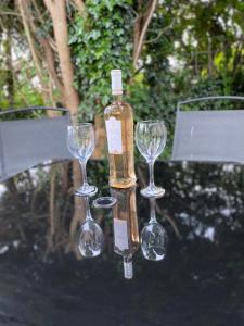 a bottle and three wine glasses on a table at “Ty Hir Caravan” Moelfre in Moelfre