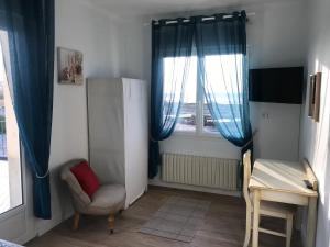 a small room with a chair and a window at La Villa Port Winston - Face Mer B&B in Saint-Côme-de-Fresné