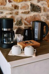 a coffee maker and two cups on a counter at Castro Rooms Chios in Chios
