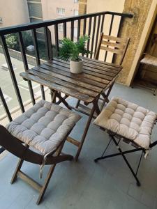 a wooden table and two chairs with a plant on a balcony at Bel Appartement Residence Mirabeau in Aix-en-Provence