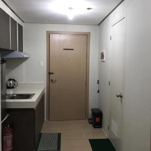 a door in a kitchen with a sink and a counter at Mplace Condo Unit _ Panay Avenue, Quezon City, Philippines in Manila