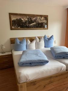 a bedroom with two beds with blue and white pillows at Gästehaus-Pension Bendler in Kirchdorf in Tirol