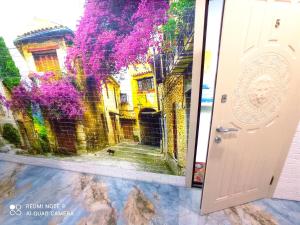 a door with a painting of a courtyard with purple flowers at Garden Love on Deribasovskaya in Odesa