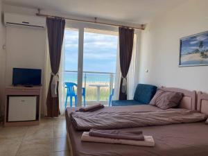 a bedroom with a bed and a view of the ocean at Hotel Joker in Lozenets