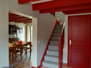 una puerta roja en una sala de estar con una escalera en La Gaucherie aux Dames, en Vihiers