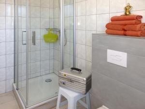a bathroom with a shower and a stool with towels at Strandhotel Villa Louisa & Appartementhäuser Villa Josephine und Villa Christine in Juliusruh +82 photos