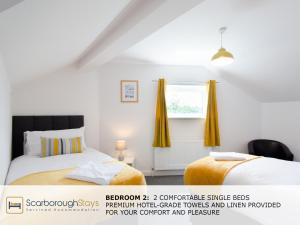 una camera con due letti e una finestra di Candler Lodge - 3 BEDROOM TOWNHOUSE WITH PARKING - PATIO AREA & SEATING a Scarborough