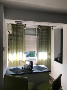 Open Space Mini Craiovei في بيتشتي: غرفة معيشة مع طاولة ونافذة