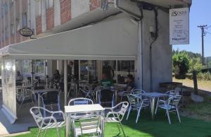 a group of tables and chairs in front of a building at A Senda in Caldas de Reis