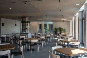 Un comedor con mesas y sillas y ventanas. en SHAMBALA WELLNESS CLUB, en Rozhny