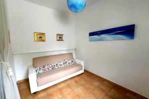 Casa Blu في سيكيتو: غرفة بها أريكة ولوحة على الحائط