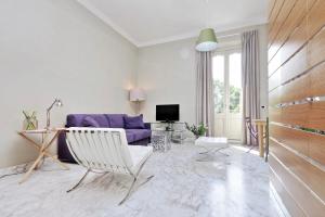 a living room with a purple couch and a chair at Fontana Più Stella in Rome