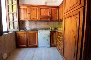 a kitchen with wooden cabinets and a white dishwasher at Casa Vacanze Dante in Gorfigliano
