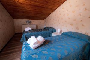 a bedroom with two beds and a wooden ceiling at Casa Vacanze Dante in Gorfigliano