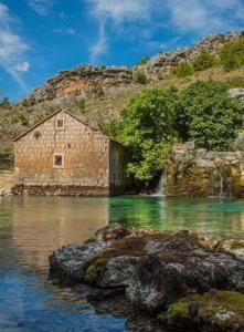 an old building sitting in the middle of a river at House for rest Ruda in Grab