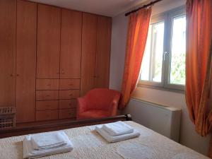 a bedroom with a bed and a chair and a window at Sior Dionysios in Argostoli