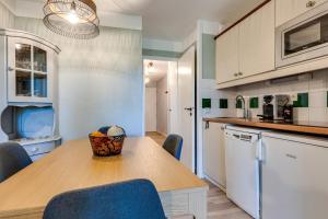 une cuisine avec une table en bois et des chaises bleues dans l'établissement Le Zeste, à Soustons 6 autres photos