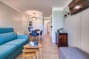 un salon avec un canapé bleu et une table dans l'établissement Le Zeste, à Soustons