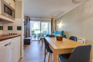 une cuisine et une salle à manger avec une table et des chaises dans l'établissement Le Zeste, à Soustons