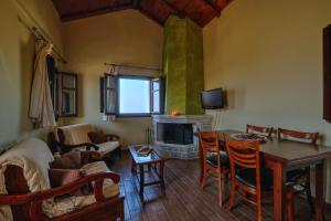 ein Wohnzimmer mit einem Tisch und einem Kamin in der Unterkunft Achelatis Traditional Guest Houses in Areopoli