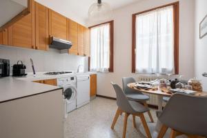 a kitchen with a table and chairs in a kitchen at Ca’ Pesaro rooftop terrace apartment. in Venice
