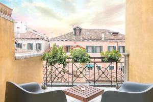 a balcony with a table and chairs and a view of a building at Ca’ Pesaro rooftop terrace apartment. in Venice