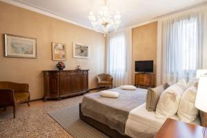 a bedroom with a large bed and a television at Ca’ Pesaro rooftop terrace apartment. in Venice