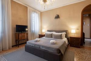 a bedroom with a large bed with two towels on it at Ca’ Pesaro rooftop terrace apartment. in Venice