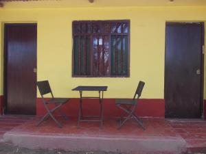 une table et deux chaises devant un bâtiment dans l'établissement Rancho Santana Horseback Riding, à Pacora