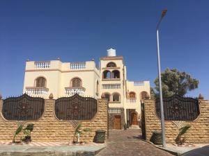 een groot wit gebouw met een hek ervoor bij Villa 22 in Dahab