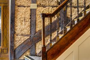 una escalera en una casa con una pared de piedra en The George Hotel en Colchester