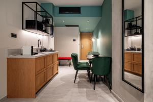 a kitchen and dining room with a table and green chairs at Bob W Athens Akadimia in Athens +64 photos