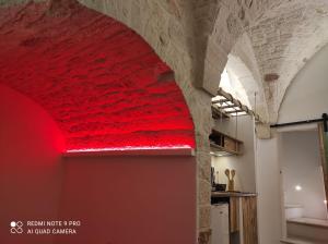 a red light on the wall of a room with a brick wall at Dimora 'a Petr - Suite 'a Petr in Ceglie Messapica