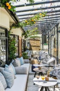 un patio al aire libre con mesas, sofás y naranjas en The George Hotel, en Colchester