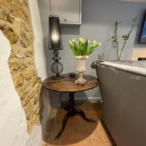 a table with a lamp and a vase with flowers on it at Box Barn - Stylish Accommodation in Rutland in Uppingham